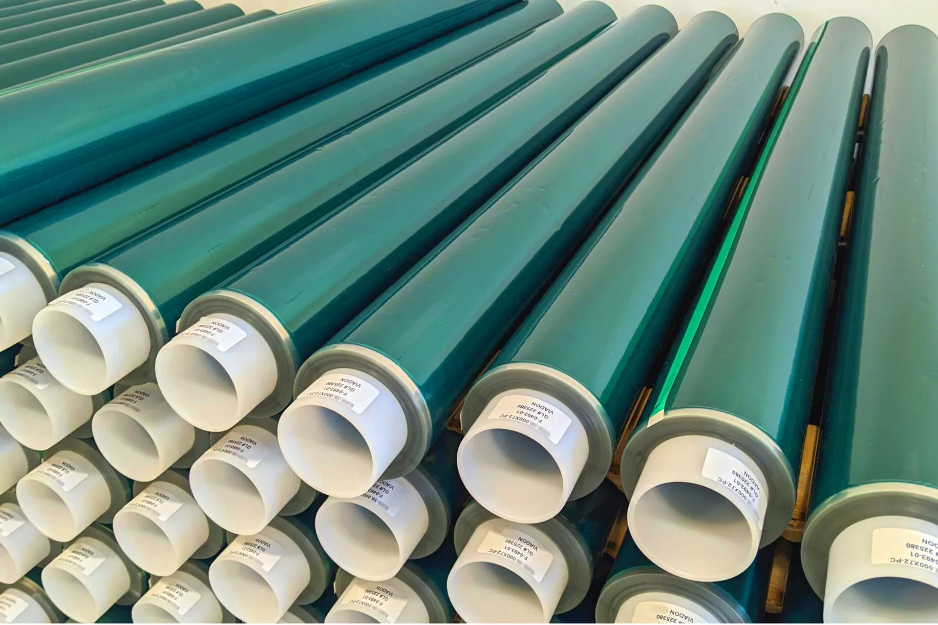 Log rolls of green polyester powder coating tape prior to being slit to width